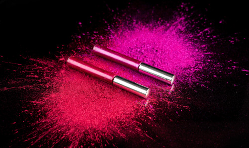 Carmine free pink and purple powder on black background
