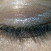 A very up close image of an eye with silver eyeshadow