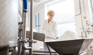 Lady working in a factory with a pile of powder