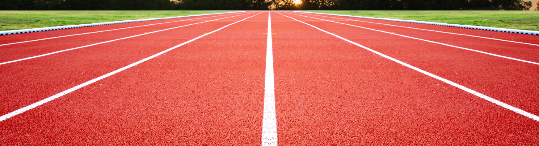 A picture of a running track with a sunset